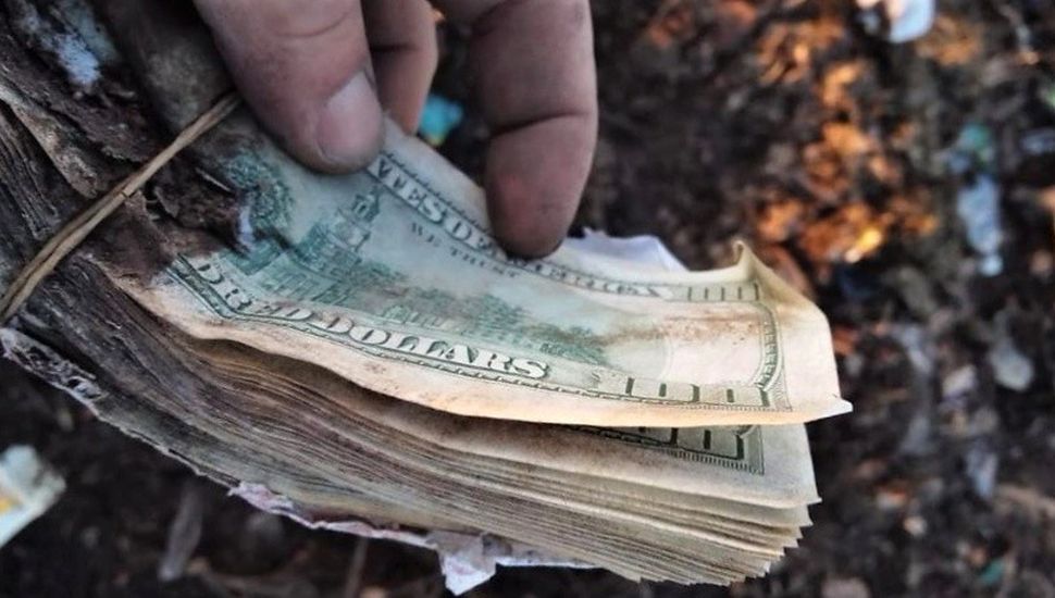Un pueblo busca dólares en la basura tras el hallazgo de un “tesoro”